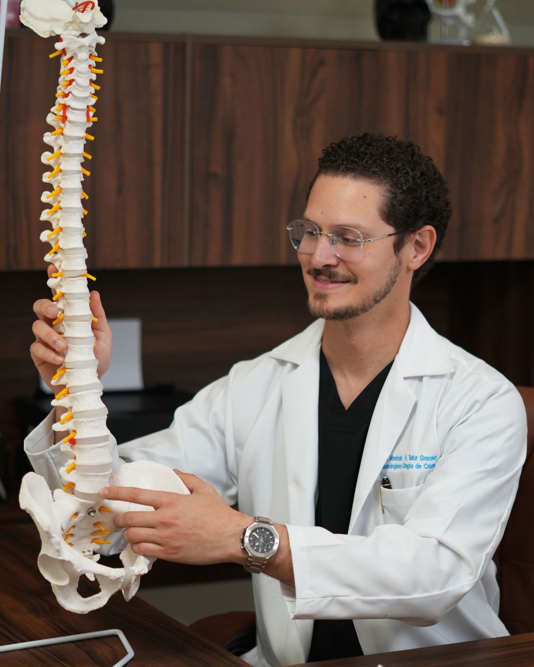 Dr. Tafur examinando columna vertebral anatómica